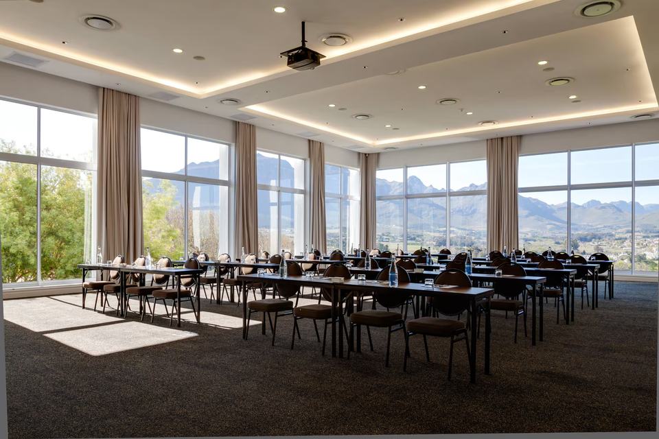 A conference room set up with long tables, with mountain views through tall windows.